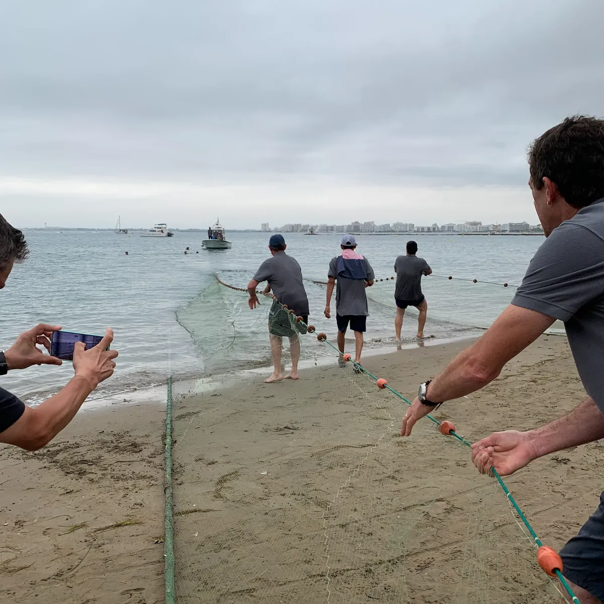 Pescadors estirant la xarxa a la platja durant la Tirada d’Artó de Sant Pere